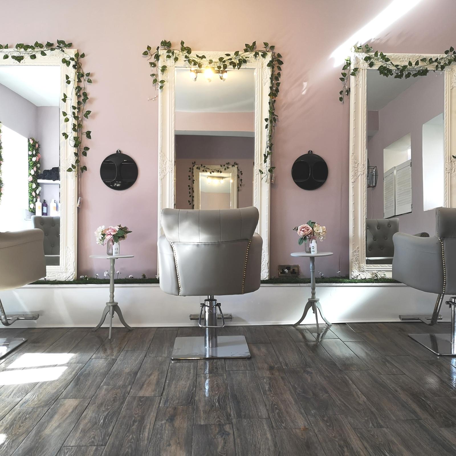 Our first salon: pink walls and three ivy-framed mirrors over grey chairs